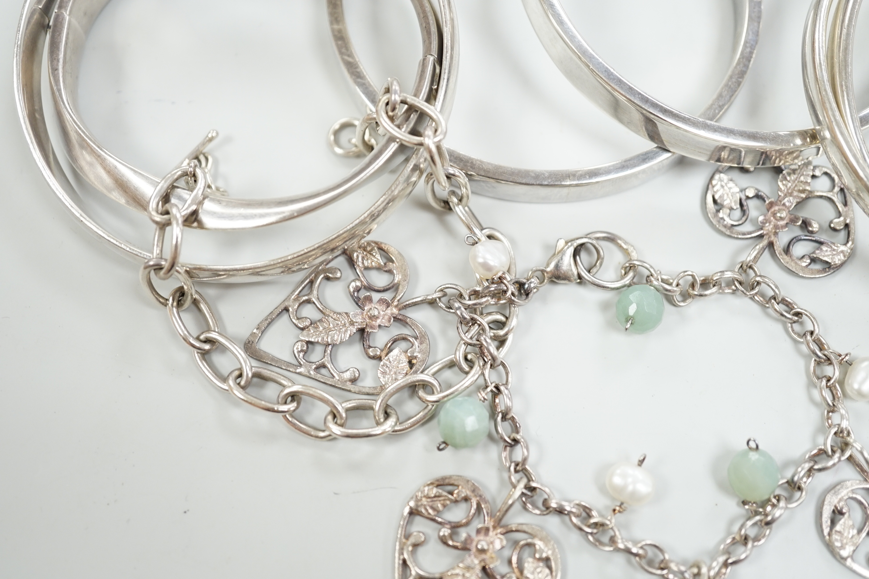 Three Pruden Smith bangles including triple loop, two other silver bangles, a white metal heart bracelet and one other bracelet, together with a straight edge rule by Mary Ann Simmons.